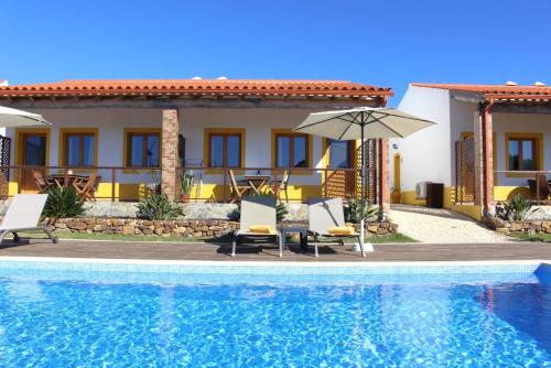 a villa with a swimming pool and a house at Quinta das Alfambras in Aljezur