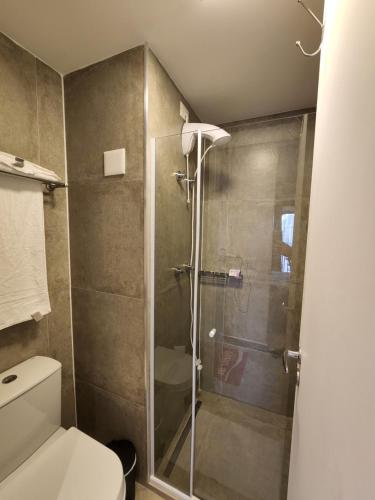 W łazience znajduje się toaleta i przeszklony prysznic. w obiekcie Studio SP ao lado Shopping Frei Caneca w São Paulo