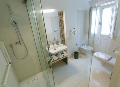 een badkamer met een douche, een wastafel en een toilet bij Dione Apartments by Dimore in Sicily Ortigia in Siracusa