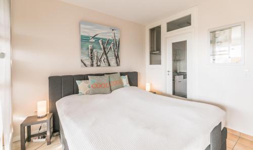 ein Schlafzimmer mit einem Bett mit einer weißen Tagesdecke in der Unterkunft "Strandresidenz Rosengarten" Str Resid -Rosengarten, Deichperle Whg 103 in Büsum