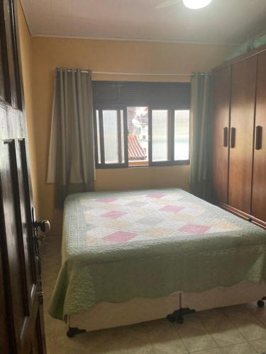 1 dormitorio con cama y ventana en Morada do Galo Praia Grande, en Arraial do Cabo