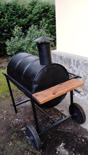a black barbecue grill with a wooden table on wheels at Cabañas Gnionguis in Villa La Angostura