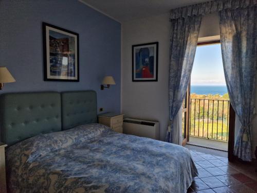 1 dormitorio con cama y vistas al océano en Hotel Hermitage, en Castellabate