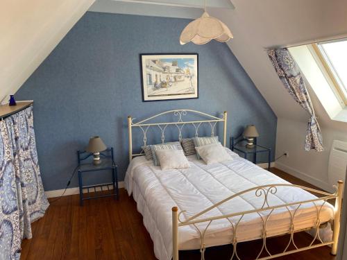 a bedroom with a bed with a blue wall at L'air marin in Plozévet