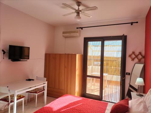 a bedroom with a bed and a desk and a window at Casa Vacanza Da Rosa in Letojanni