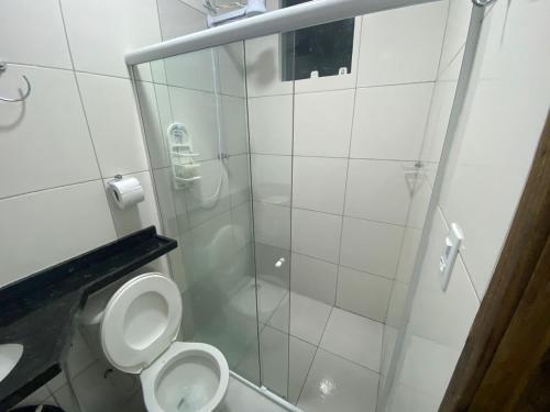 W łazience znajduje się toaleta i przeszklony prysznic. w obiekcie Vila Bangalô w mieście São José da Coroa Grande