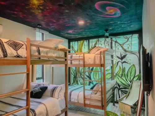 a room with three bunk beds with a mural at PH-4-Groups 3BR Priv-RoofTop 18Pax @Aldea Zama in Tulum