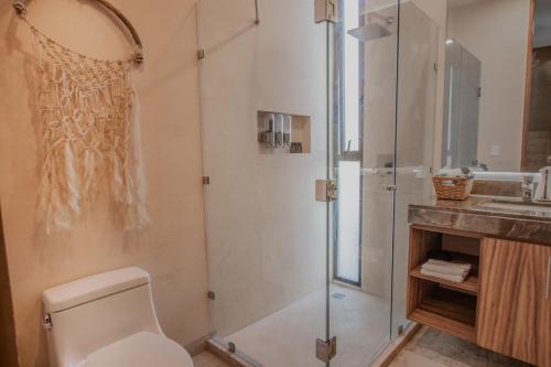 a bathroom with a shower and a toilet and a sink at PH-4-Groups 3BR Priv-RoofTop 18Pax @Aldea Zama in Tulum