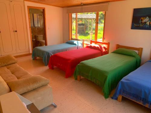 a living room with three beds and a couch at Paipa de ensueño en casa Sochaloma in Paipa