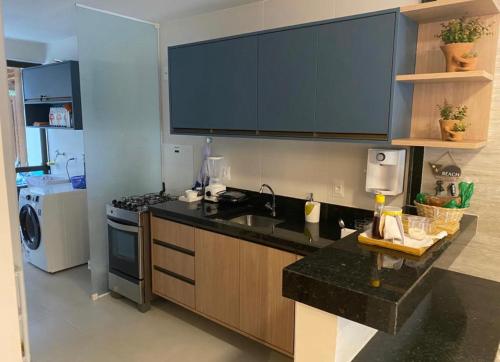a kitchen with a sink and a stove at Itacimirim pé na areia 2Q in Itacimirim
