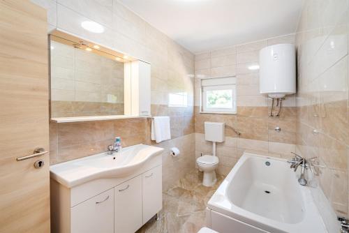 een badkamer met een witte wastafel en een toilet bij MY DALMATIA - Holiday home Zara with private swimming pool in Stankovci
