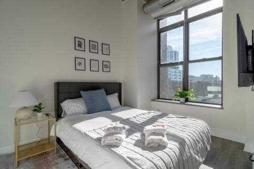 1 dormitorio con 1 cama grande y toallas. en McCormick Place beautiful 2b-2b apartment with optional parking - sleeps up to 6 en Chicago