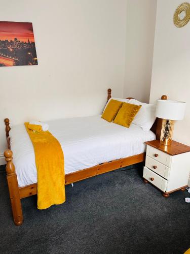 um quarto com uma cama e uma mesa de cabeceira com um candeeiro em Blessed Roker home with free parking. em Monkwearmouth