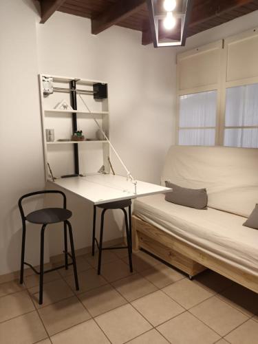1 dormitorio con escritorio, 1 cama y 1 silla en Departamento Zanzin en Mendoza