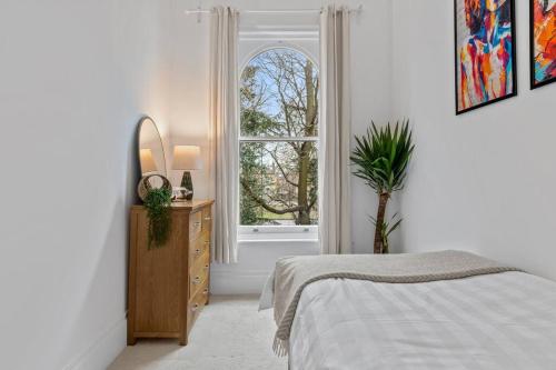 a bedroom with a bed and a dresser and a window at Cosy Apartment in the heart of Southampton in Southampton