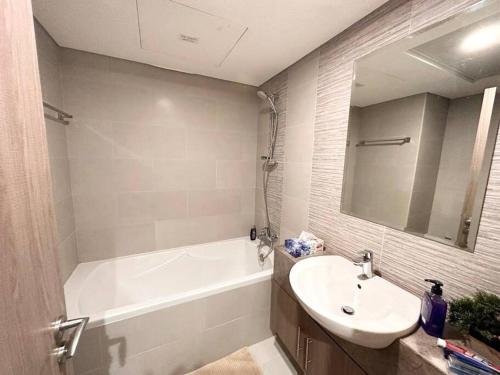 a bathroom with a sink and a bath tub and a mirror at Home in Abu Dhabi