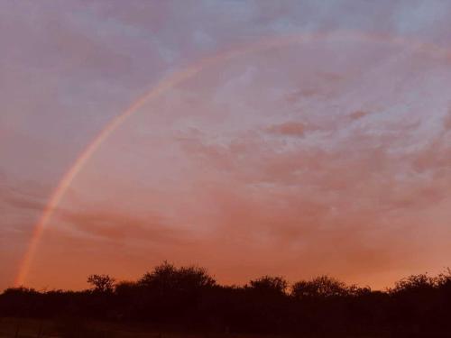 a double rainbow in the sky at sunset at Estancia San Carlos in Luan Toro