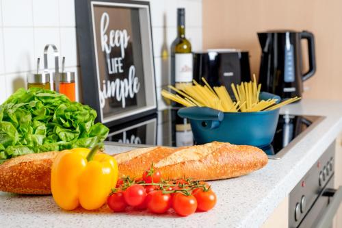a counter with tomatoes and vegetables on a counter top at HAMA Design Homes Lippstadt in Lippstadt
