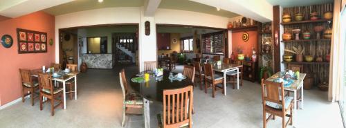 uma sala de jantar com mesas e cadeiras num restaurante em Pousada Bem Te Vi em Guarapari