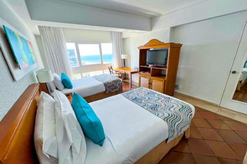 a hotel room with two beds and a television at Hotel Almirante Cartagena Colombia in Cartagena de Indias