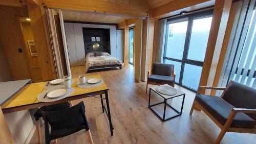 Habitación con cama, mesa y sillas. en Hermoso y cálido departamento en el centro de SMA, 21V5 en San Martín de los Andes