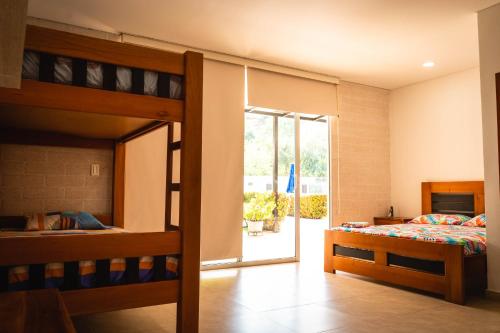 1 dormitorio con 2 literas y puerta corredera de cristal en Villa California, en Sopetrán