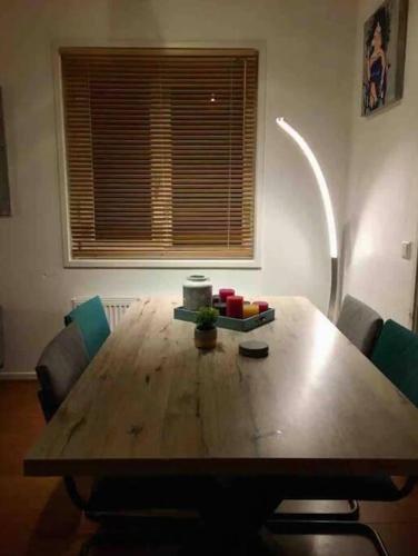 a wooden table with chairs in a room with a window at Heerlijk huis in een prachtige bosrijke omgeving. in Putten