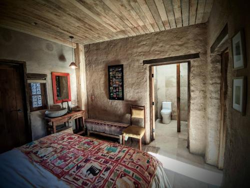 a bedroom with a bed and a chair in a room at Espacio Adobe - Hostal Boutique in Diego de Almagro