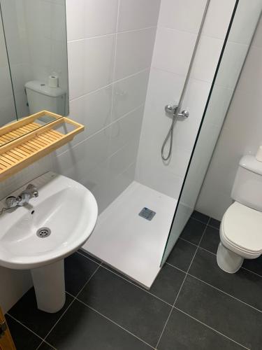 y baño con ducha, lavabo y aseo. en Pension Valcarce, en Ponferrada