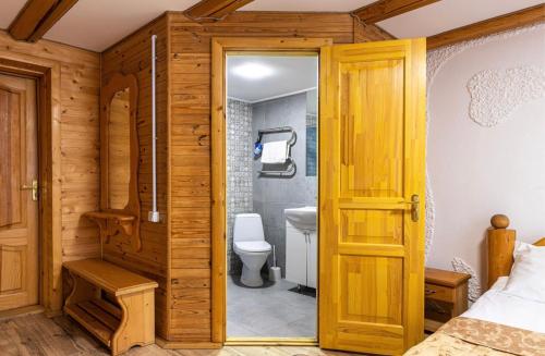 een badkamer met een toilet en een houten deur bij ВІДЕНЬ in Slavske