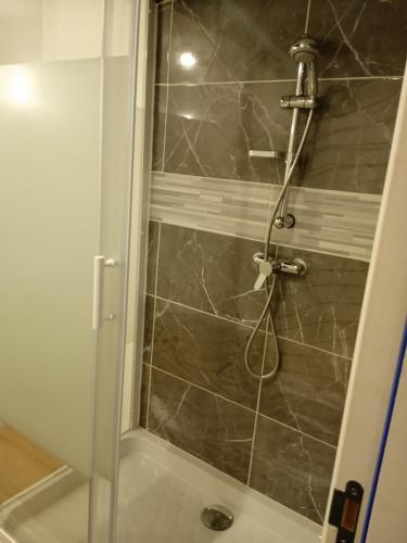 y baño con ducha y puerta de cristal. en Bienvenue à Saint Julien De Vouvantes - Dormir Comme A La Maison 
