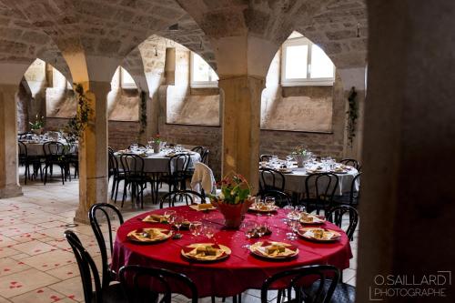 une salle à manger avec des tables, des chaises et un tissu de table rouge dans l'établissement Domaine Ferme Sainte Anne, à Langres