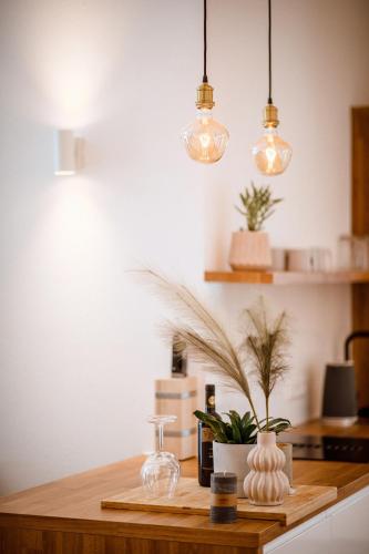 a kitchen counter with two glass vases and lights at Da Alois - Alpine Premium Apartments in Gröbming