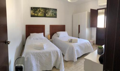 een slaapkamer met 2 bedden en witte lakens bij Sunset Casita in Alora