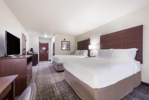 um quarto de hotel com duas camas e uma televisão de ecrã plano em Cobblestone Hotel & Suites - Seward em Seward