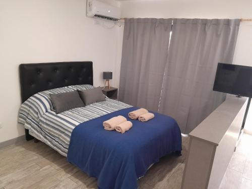 1 dormitorio con 1 cama con 2 toallas en París 2 Monoambiente en Rosario