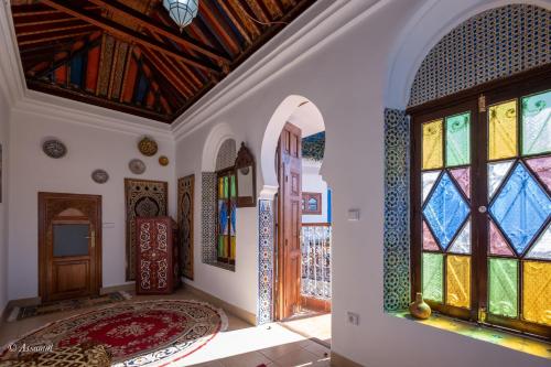 a room with stained glass doors and a rug at Riad Bin Souaki in Chefchaouene
