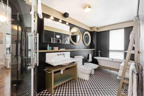 a bathroom with a sink and a toilet and a bath tub at Waterfront Luxury in Dublin