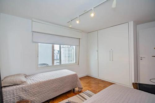 1 dormitorio con 2 camas y ventana en Apartamento charmoso próx à Av Paulista, en São Paulo