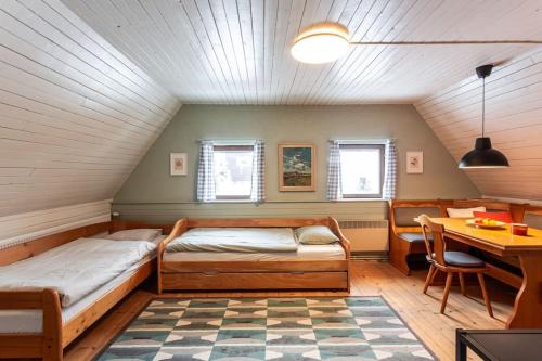 a bedroom with two beds and a desk and a table at Chata u Židle in Boží Dar