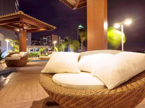Una cama de mimbre sentada en un patio por la noche en Flat in Salvador, en Salvador