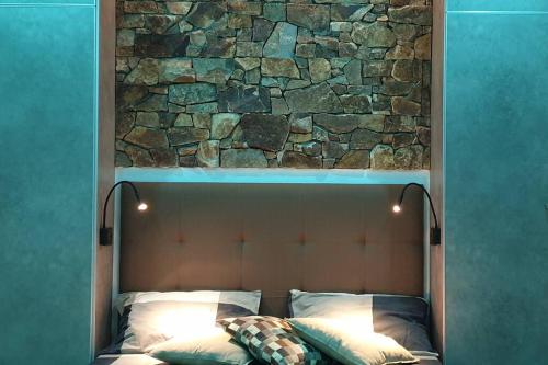 a bed with a stone wall above it at 5 star Smart studio 30m2 in Flic-en-Flac