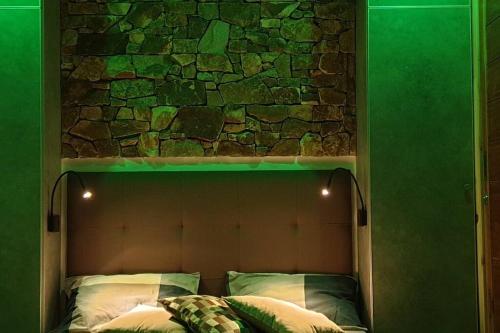 a bed with a stone wall above it with green lights at 5 star Smart studio 30m2 in Flic-en-Flac