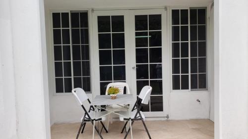 a table and chairs on a patio with a door at ROSI Ocean Sand Hotel Apt (@Sandcastles) in Ocho Rios