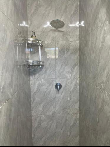 a shower with a glass door in a bathroom at Tia Maria cottage in Cape Town