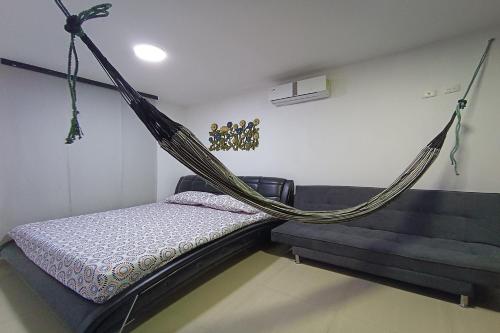 a bed with a hammock in a room at Ayenda Brisas del Rio in Barranquilla