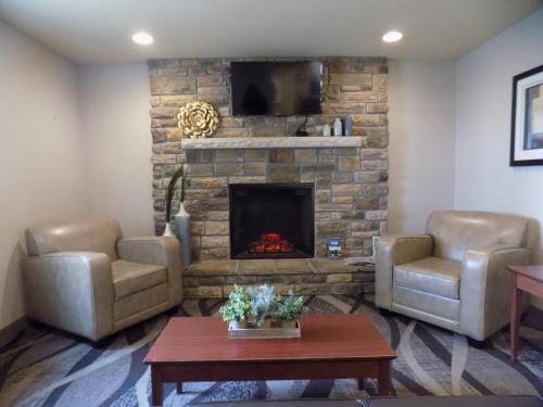 a living room with two chairs and a fireplace at Cobblestone Hotel & Suites - Seward in Seward