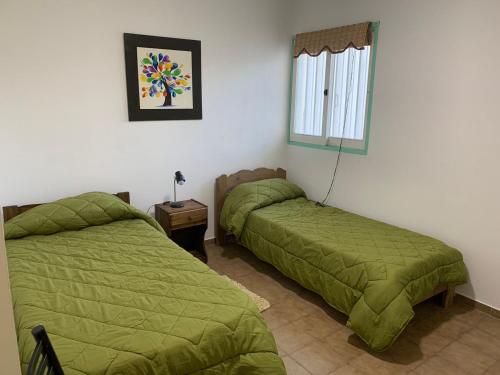 2 camas en una habitación con edredón verde en Apartamento amoblado excelente ubicación en San Rafael