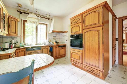 a kitchen with wooden cabinets and a table in it at Jagdreich im Westerwald 