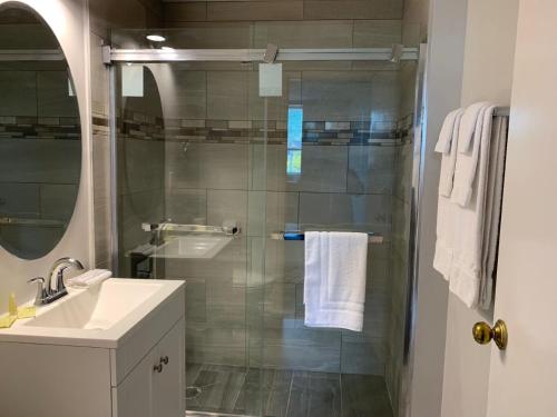 a bathroom with a glass shower and a sink at Royal Inn and Suites at Guelph in Guelph